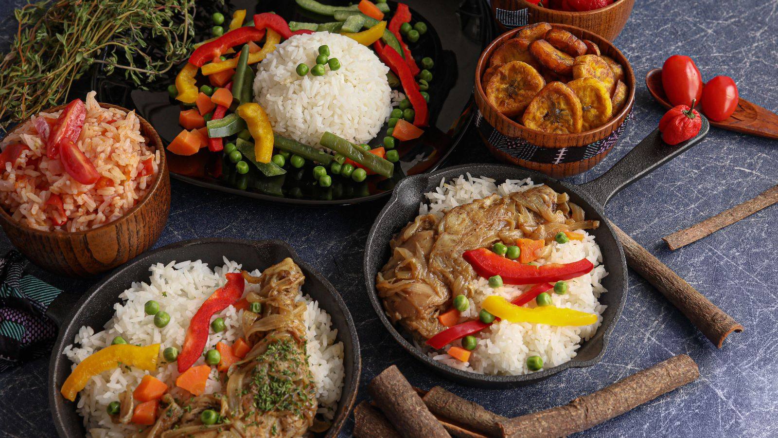 A spread of West African dishes with rice, plantains and peppers