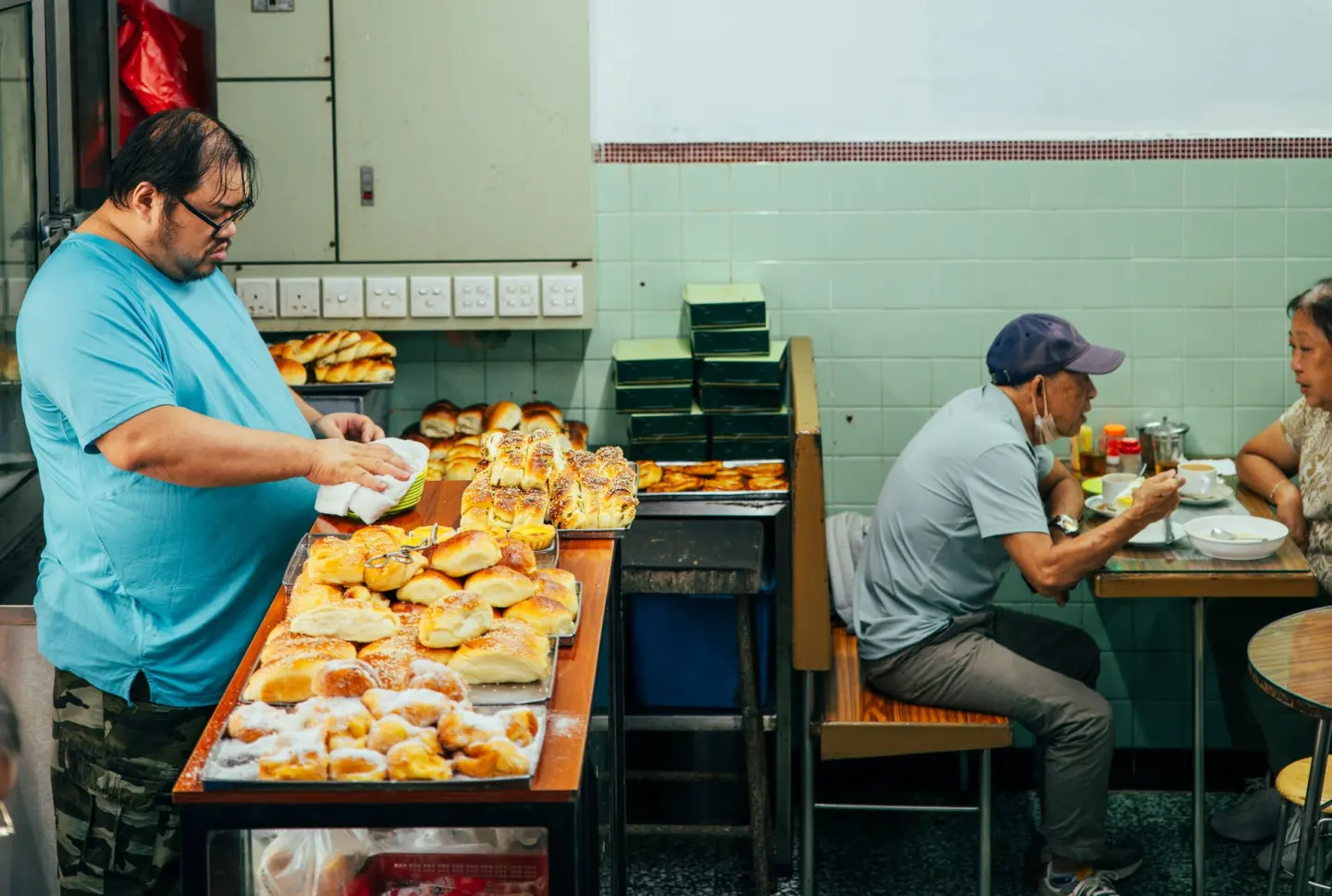 A serene moment in a local bakery with fresh bread and customers enjoying a meal.